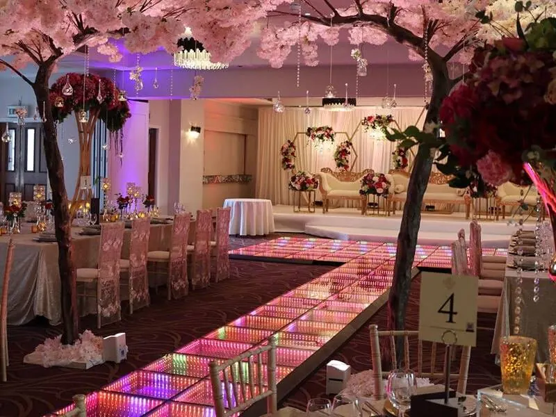 LED panels laid as a glowing aisle between reception tables, leading to the head-table stage